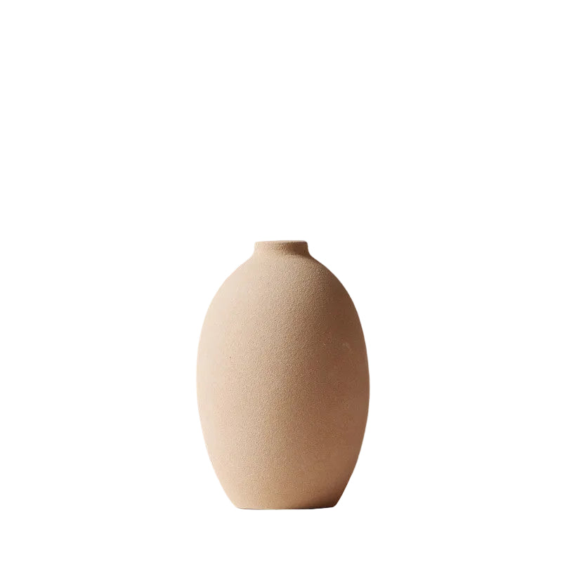 Beige ceramic vase on a white surface with a gray background