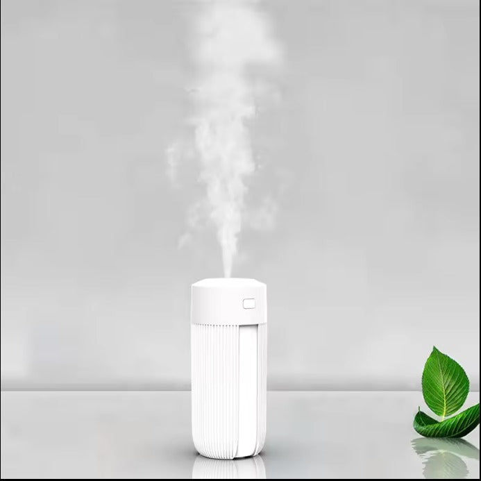 image White humidifier emitting steam on a gray background with a green leaf