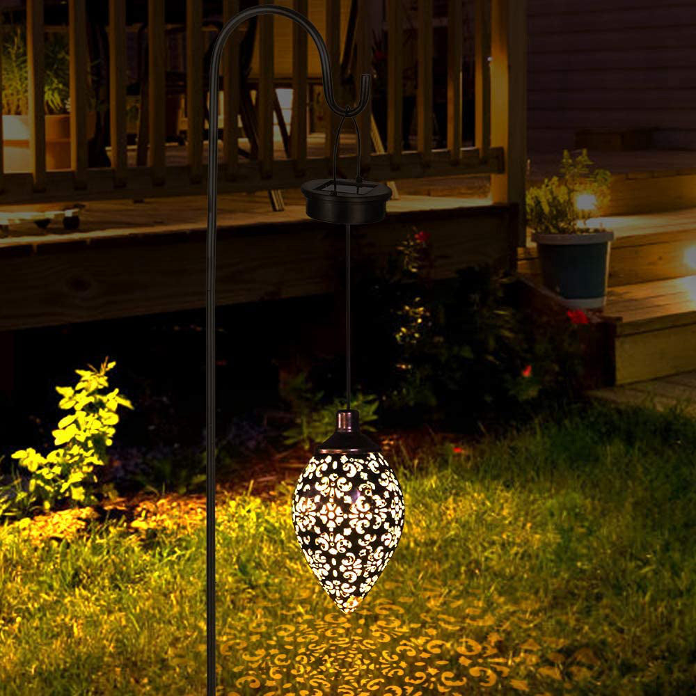 image Decorative solar light in a garden setting with a wooden deck in the background.