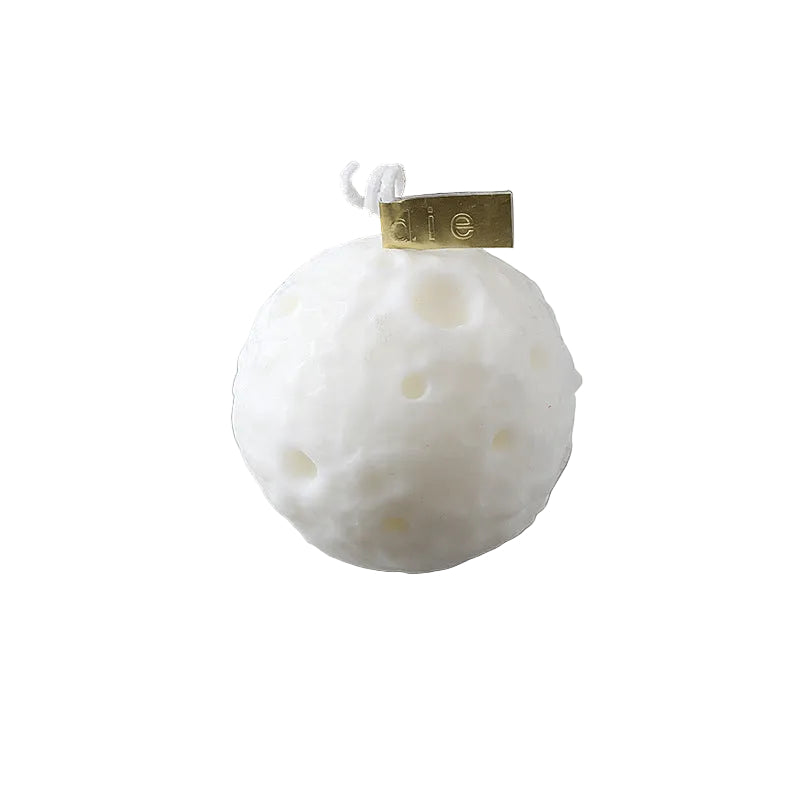 White spherical product with a gold tag on a book, showing measurements.