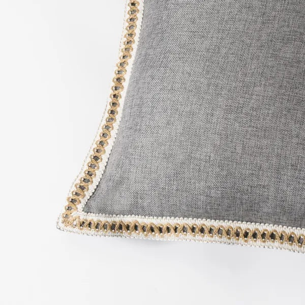 image Gray pillow with decorative trim on a white background
