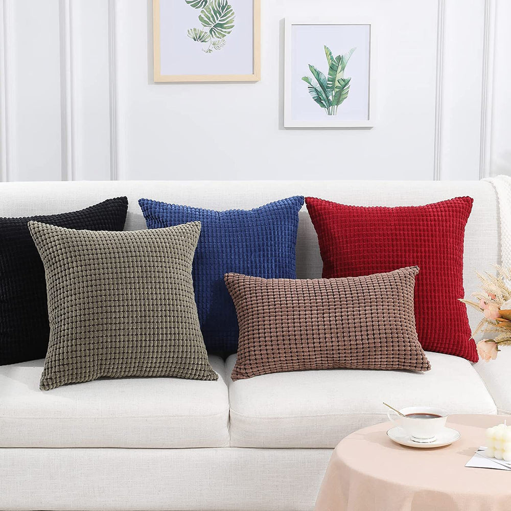 Colorful textured pillows on a white sofa with a neutral background