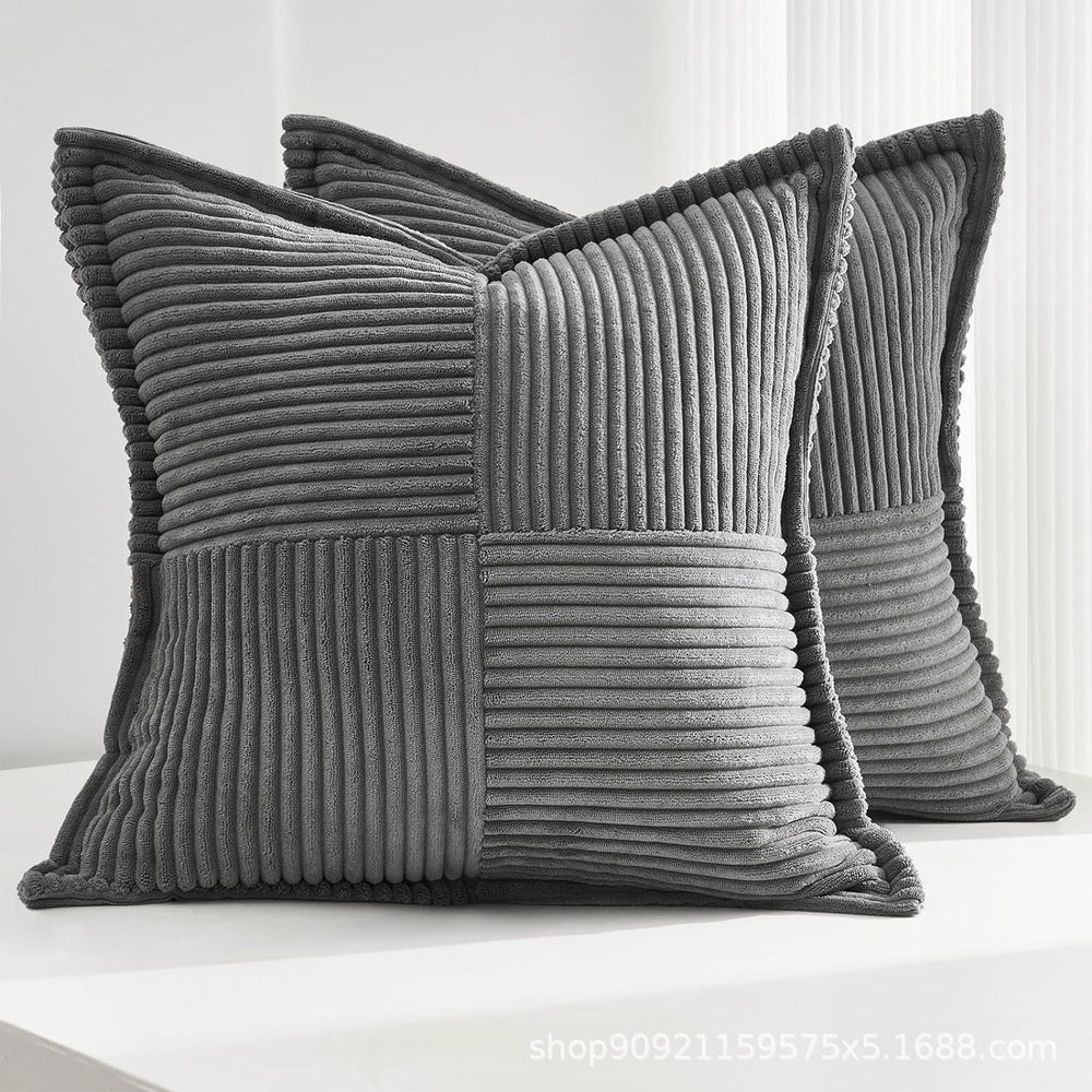 Two gray textured pillows on a white surface with a light gray background