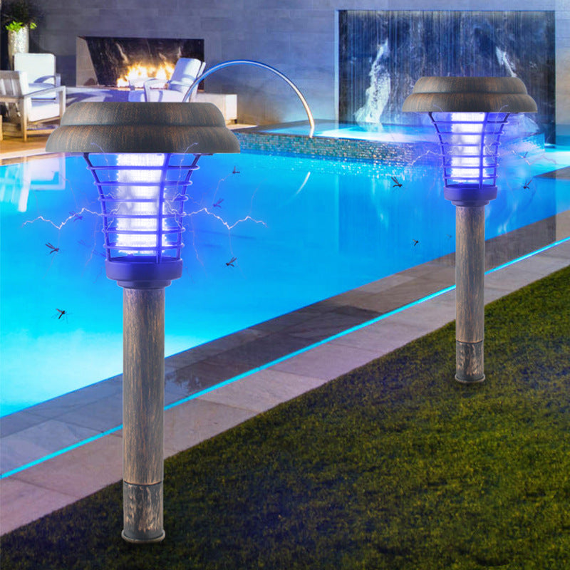 Two solar-powered garden lights by a pool with a fireplace and water feature in the background.