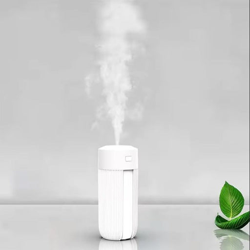 White humidifier emitting steam on a light gray background with a green leaf