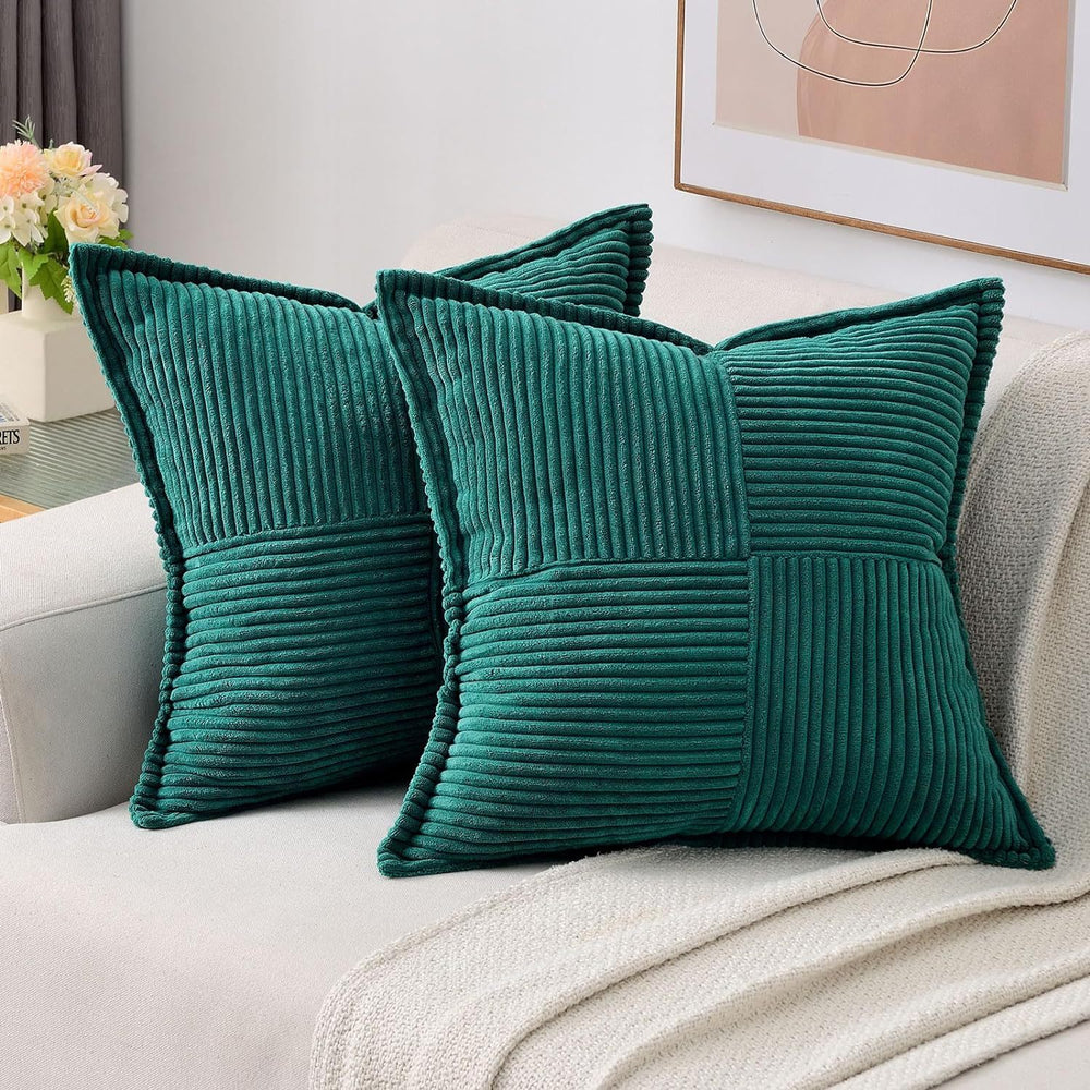 Two teal pillows on a light-colored sofa with a neutral background