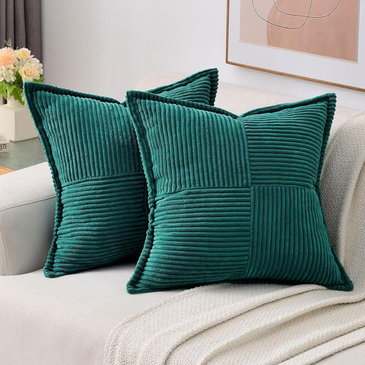 Two teal pillows on a light-colored sofa with a neutral background