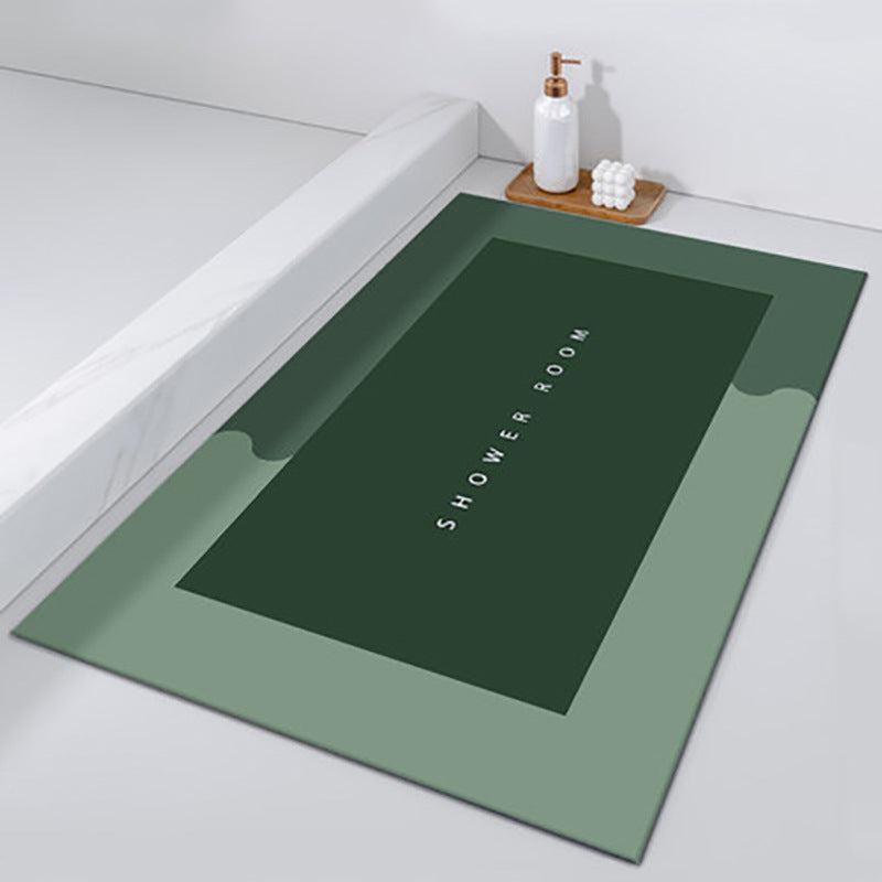 Green bath mat with 'SHOWER ROOM' text on a bathroom floor.