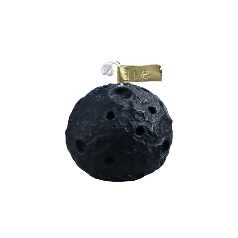 image Black textured ball with a gold tag on a gray surface, showing measurements.