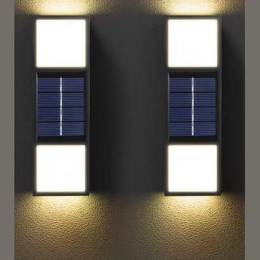 Two solar wall lights on a textured wall