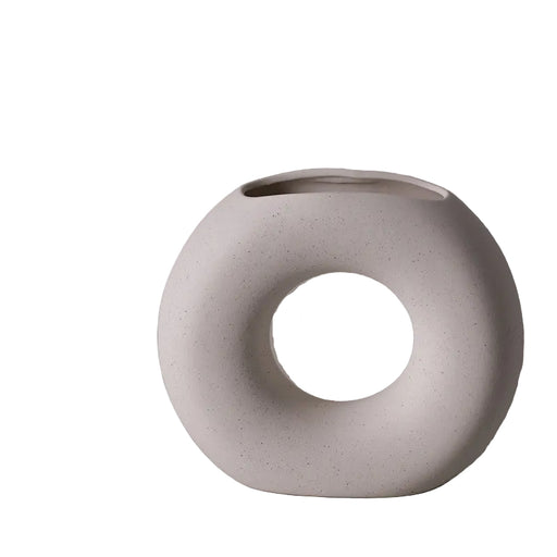 White ceramic vase with circular design on a gray background