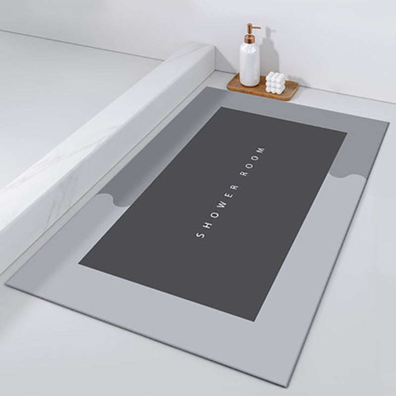Gray bath mat with 'SHOWER ROOM' text on a white bathtub