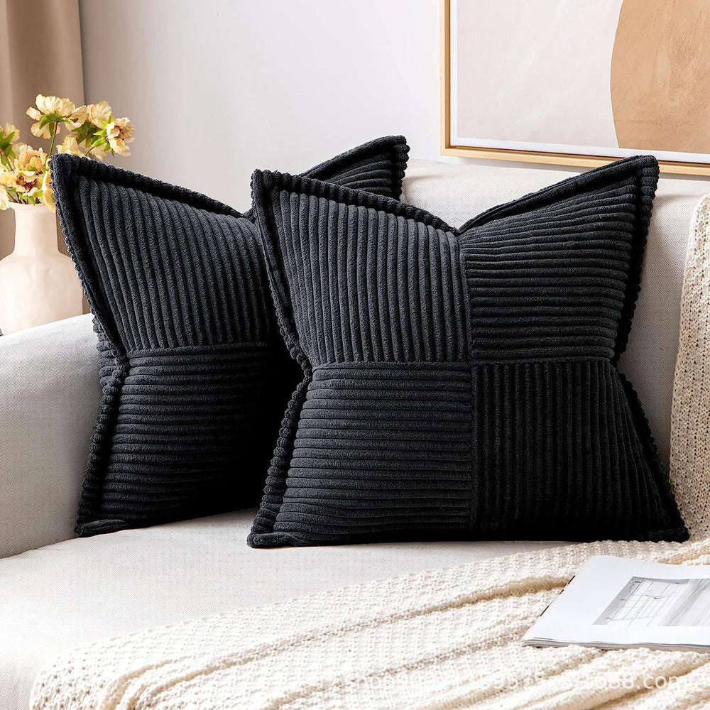 Black textured pillows on a sofa with a neutral background