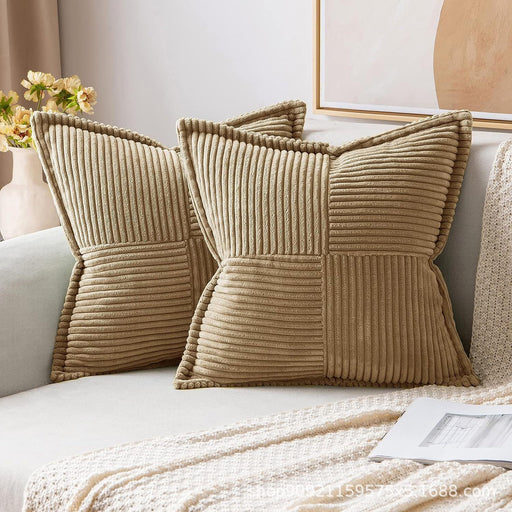 Beige textured pillows on a sofa with a lamp and flowers in the background