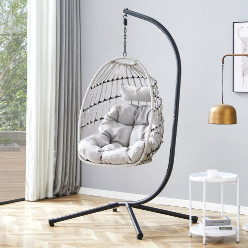 Hanging chair with cushion in a room with a side table and lamp.